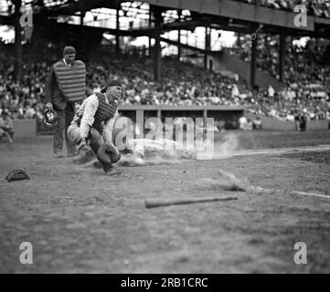 Washington, D.C.: c. 1926. Gli Yankees Lou Gehrig segnano il primo posto nel quarto inning mentre il lancio di Joe Harris si allontana dal ricevitore Hank Severeid dei Washington Senators. Gli Yanks batterono i Senators 3-2. Foto Stock