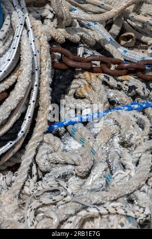 un groviglio di corde, fili e vecchie reti in un mucchio di nodi sul muro del porto di pesca a spalato in croazia. Foto Stock