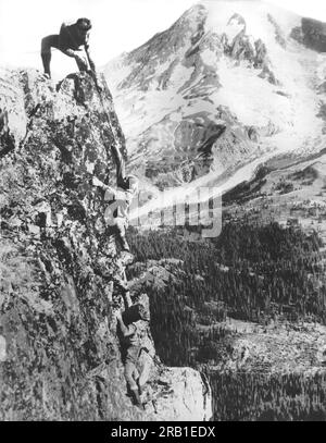 Mount Rainier National Park, Washington: 15 agosto 1925 Un gruppo di tre alpinisti proprio mentre stanno per raggiungere la cima del Pinnacle Peak che si affaccia sulla Paradise Valley. Foto Stock