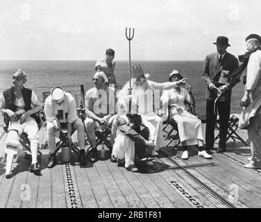 Oceano Pacifico: 15 ottobre 1942 la corte di Neptunus Rex, Ruler of the Raging Main, si riunisce sul ponte di un U.S. Portaerei della Marina mentre si avvicina all'equatore. La corte entrerà in azione per convertire i "pollywogs" (uomini che non hanno mai attraversato l'equatore) in "conchiglie" una volta completati i rituali. Foto Stock