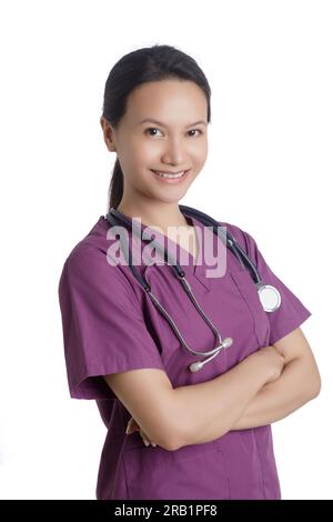 Bella donna asiatica Dottore o infermiera vestita con scrub viola isolata su uno sfondo bianco con spazio per la copia Foto Stock
