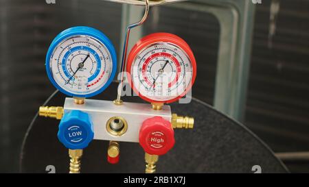 Immagine ravvicinata del dispositivo di misurazione della pressione utilizzato per controllare la pressione del freon del condensatore. Serie di indicatori del collettore che mostrano livelli di refrigerante alti o bassi nel condizionatore d'aria per esterni Foto Stock