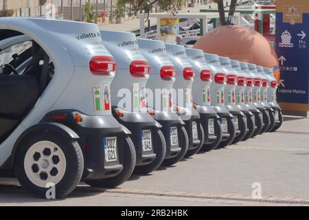 Una fila di 12 quadricicli elettrici Renault Twizy disponibili per il noleggio, per ospitare due occupanti seduti in tandem, Valletta, Malta, aprile 2023. Foto Stock