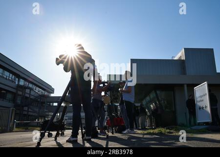 Itzehoe, Germania. 7 luglio 2023. Gli equipaggi televisivi e i giornalisti attendono fuori dall'ingresso del China Logistic Center, dove il processo per omicidio e tentato omicidio nel caso dell'attacco di coltello sul treno vicino a Brokstedtvor inizia venerdì al tribunale regionale di Itzehoe. Credito: Christian Charisius/dpa/Alamy Live News Foto Stock