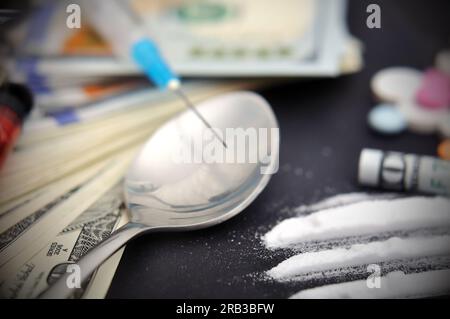 Siringa, cocaina e dollari su sfondo nero Foto Stock