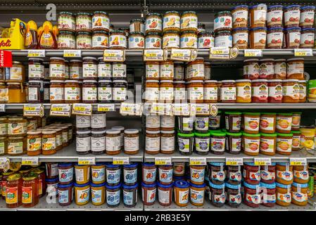 Italia - 06 luglio 2023: Marmellata e marmellata in vasetti di vetro di diverse tipologie e marche in vendita negli scaffali dei supermercati italiani Foto Stock