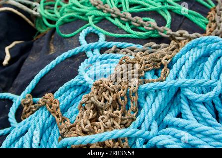 Un mucchio di falchi e catene che giacciono in un peschereccio in un porto in Francia. Foto Stock