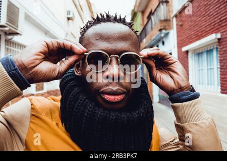 primo piano di bel giovane africano con occhiali da sole all'aperto Foto Stock
