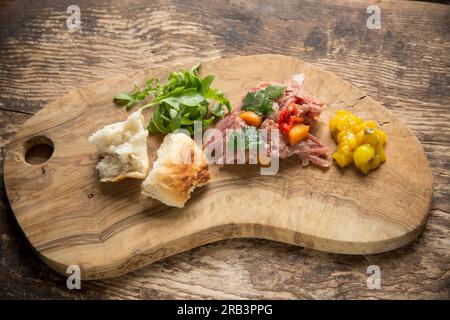 Uno stinco di gammon britannico cucinato in casa che è stato cotto lentamente in acqua, aceto di vino bianco, foglie di alloro, semi di coriandolo e peperoni neri per fare una ter Foto Stock