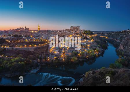 Skyline di Toledo con cattedrale, Alcázar e fiume Tago di notte - Toledo, Spagna Foto Stock