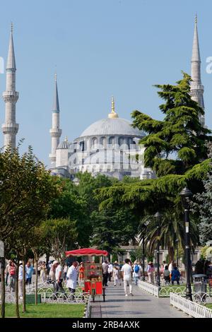 Sultan Ahmed alias Moschea Blu nell'area di Sultanahmet. I Simits, noti anche come bagel turchi, sono venduti da un carrello rosso nei giardini. Istanbul, Turchia Foto Stock