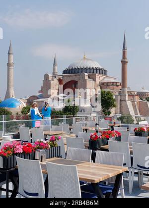 Due turisti apprezzano la vista dalla terrazza del ristorante Seven Hills verso la Moschea di Santa Sofia, Sultanahmet, Istanbul, Turchia Foto Stock