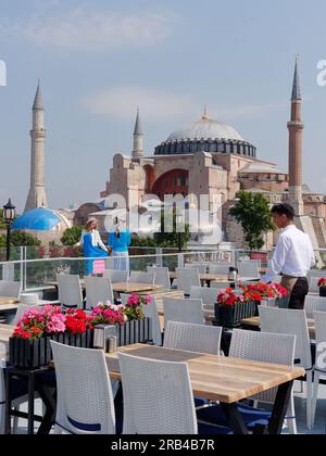 Due turisti apprezzano la vista dalla terrazza del ristorante Seven Hills verso la Moschea di Santa Sofia, Sultanahmet, Istanbul, Turchia Foto Stock