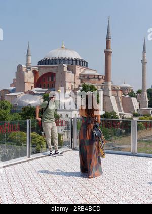 Due turisti apprezzano la vista dalla terrazza del ristorante Seven Hills verso la Moschea di Santa Sofia, Sultanahmet, Istanbul, Turchia Foto Stock