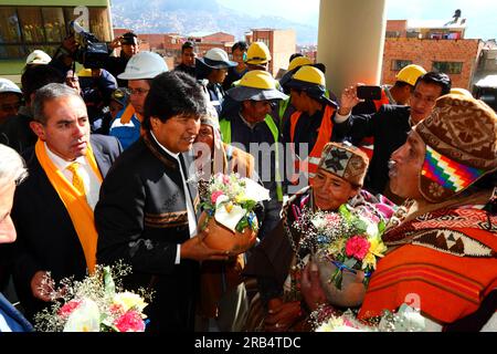 La Paz, Bolivia, 15 settembre 2014. il presidente boliviano Evo Morales (al centro) riceve un vaso di ceramica con offerte da un Aymara amauta o sciamano durante la cerimonia di apertura della linea gialla. La linea gialla è la seconda delle tre linee di cabinovie aperte quest'anno e fa parte di un ambizioso progetto volto ad alleviare la congestione del traffico. La prima linea è stata aperta a maggio, quando tutte e tre saranno aperte, sarà la più lunga funivia urbana del mondo. Foto Stock