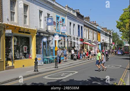 Londra, Regno Unito: Negozi e caffè in Pembridge Road, Notting Hill Gate, una delle zone più ricche di Londra. Sono impegnato con la gente in una calda giornata estiva. Foto Stock