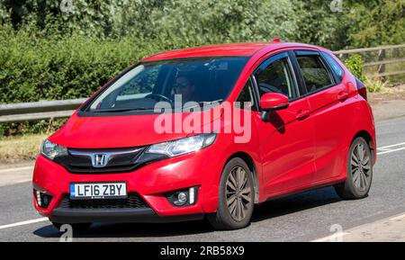 Milton Keynes, Regno Unito - 7 luglio 2023: 2016 auto rossa HONDA JAZZ che viaggia su una strada del Regno Unito Foto Stock