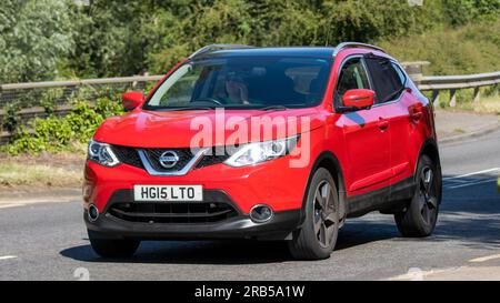 Milton Keynes, Regno Unito - 7 luglio 2023: 2015 auto NISSAN QASHQAI rossa che viaggia su una strada del Regno Unito Foto Stock