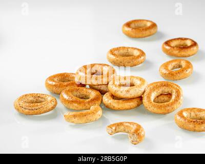 Fast food. Un mucchio di pretzel croccanti per colazione su sfondo bianco. Foto Stock