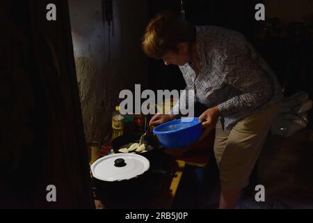 Huliaipole, Ucraina. 28 giugno 2023. La donna sta cucinando un cucchiaio di pane in un rifugio antiatomico a Huliaipole. Le forze russe sui fronti Zaporizhzhia e Kherson stanno concentrando i loro sforzi principali per prevenire l'avanzata delle forze ucraine. Credito: SOPA Images Limited/Alamy Live News Foto Stock