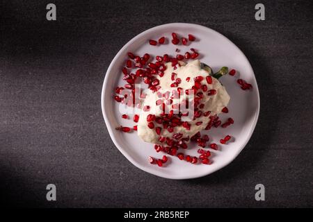 Chiles en Nogada, piatto tipico del Messico. Preparato con peperoncino poblano ripieno di carne e frutta e ricoperto di salsa di noci. Chiamato qui Foto Stock