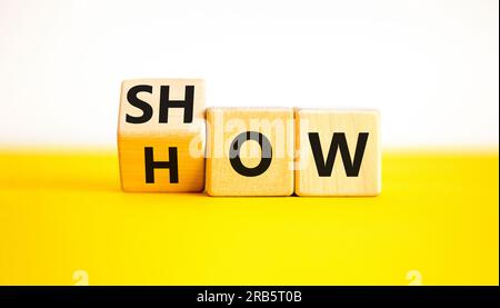 Mostra come simbolo. L'uomo d'affari gira i cubi di legno e cambia la parola Mostra a come. Bellissimo sfondo bianco tavolo giallo. Spazio di copia. Business e SH Foto Stock