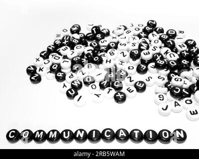 Un mucchio di lettere rotonde in bianco e nero e una parola di comunicazione scritta fianco a fianco Foto Stock