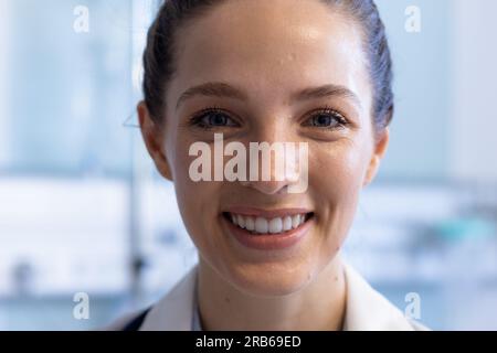 Ritratto di felice medico caucasico donna indossa uniforme medica in ospedale. Ospedale, medicina e servizi sanitari, inalterati. Foto Stock
