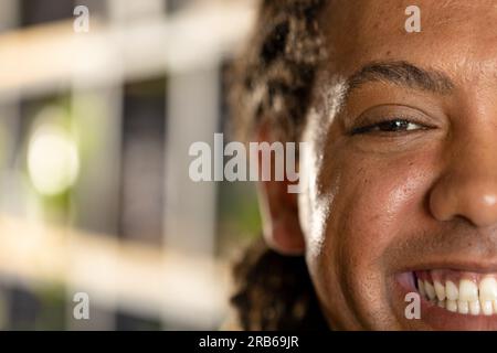 Mezzo ritratto di uomo d'affari birazziale e informale sorridente in ufficio, spazio fotocopie. Lavoro, affari, fiducia, benessere e ufficio informale, inalterato. Foto Stock