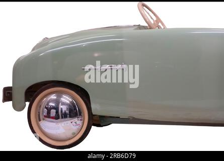 Dettaglio ravvicinato di un'auto a pedali MFA verde menta con coprimozzo rotondi lucidi, un'auto d'epoca su un giocattolo prodotto in Francia. Isolato su bianco con tracciato di ritaglio Foto Stock