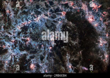 2 giugno 2023 - spazio - Un delicato tratto di polvere e brillanti ammassi di stelle si intrecciano in questa immagine del telescopio spaziale James Webb della NASA/ESA/CSA. In questa immagine, dallo strumento MIRI di Webb, la struttura polverosa della galassia a spirale e le bolle luminose di gas contenenti ammassi stellari appena formati sono particolarmente prominenti. Questi brillanti tendini di gas appartengono alla galassia a spirale barrata NGC 5068, situata a circa 17 milioni di anni luce dalla Terra nella costellazione della Vergine. Questo ritratto di NGC 5068 fa parte di una campagna per creare un tesoro astronomico, un deposito di osservazioni Foto Stock