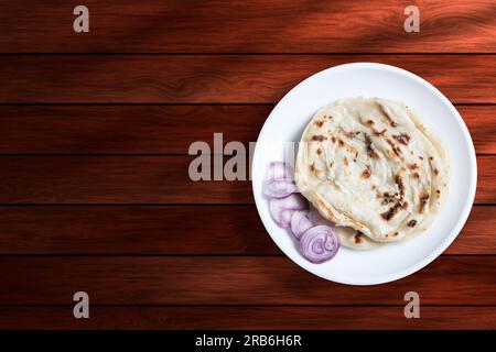 Parotta di cibo indiano con cipolla su fondo di legno. Vista dall'alto Foto Stock