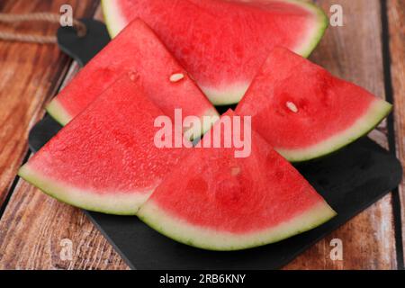 Pezzi di succosa anguria matura su tavolo di legno, primo piano Foto Stock