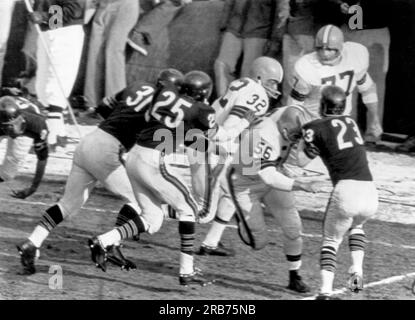 Chicago, Illinois: 10 dicembre 1961 John Morrow dei Cleveland Browns (56) blocca Dave Whitsell dei Chicago Bears (23) e la running star dei Brown Jim Brown (32) corre per 90 yard e un touchdown Foto Stock