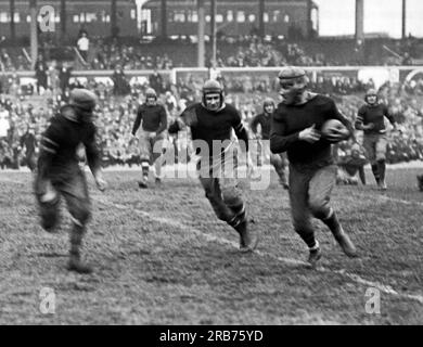 New York, New York: 11 novembre 1925 il running back rookie dei New York Giants Heinie Benkert di Rutgers che stava per essere placcato dopo una corsa da 30 yard in una gara contro i Rochester Jeffersons. Ha giocato anche per i Pottsville Maroons e gli Orange/Newark Tornadoes. Foto Stock