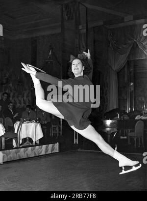 New York, New York: c. 1940 Una nuova tendenza nell'intrattenimento dei night club: Pattinaggio su ghiaccio! Questa ragazza sta mostrando quanto sia abile ad un pubblico ammiratore. Foto Stock