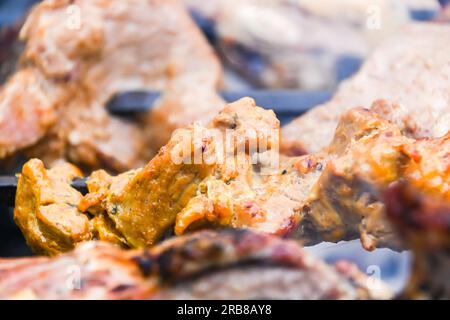 Deliziosi e sfrigolanti pezzi di carne arrostiti e grigliati su spiedini, barbecue all'aperto Foto Stock