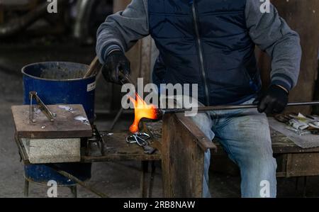 Il soffiatore di vetro di Murano ospita una scultura di cavallo in vetro caldo rosso Foto Stock