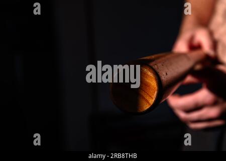 Foto astratta di un giocatore di baseball da vicino tenuto in mano da un uomo muscoloso con peli del corpo, tema di autodifesa, sport, atletica, sfondi copia spazio web Foto Stock
