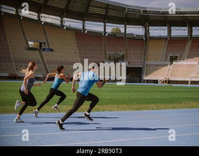 I bellissimi amici stanno allenando il loro cardio. Correre allo stadio Foto Stock