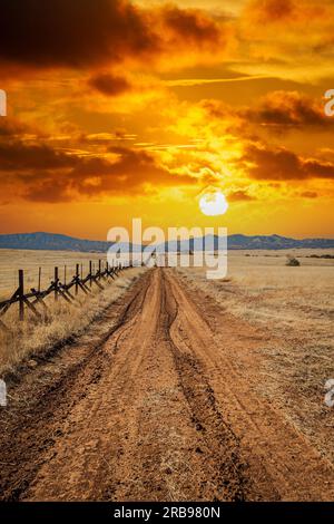 Una strada solitaria sterrata attraverso le praterie lungo il confine tra gli Stati Uniti e il Messico in Arizona. Foto Stock