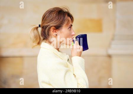 La donna felice beve acqua termale minerale salutare in uno dei famosi centri medici e terapeutici europei Foto Stock