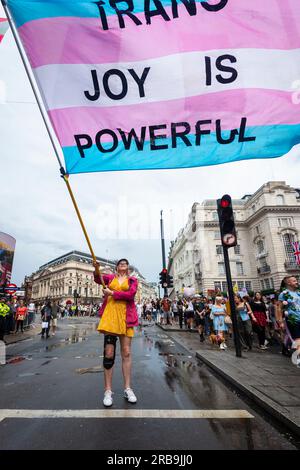 Londra, Regno Unito. 8 luglio 2023. Una persona con una bandiera vicino a Piccadilly Circus, dove i fiori erano il tema, durante Trans+ Pride a Londra, un evento per portare l'attenzione sulla comunità transgender, chiedendo la libertà transgender e l'uguaglianza nel Regno Unito e a livello globale. Crediti: Stephen Chung / Alamy Live News Foto Stock