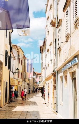 Rab Croazia - 4 luglio 2023: Strada principale della città vecchia di Rab con persone che camminano. Foto Stock