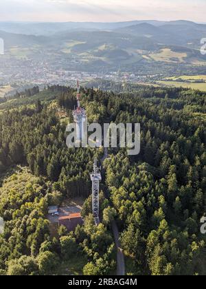 Vista aerea della cima della collina di Svatobor con una storica torre panoramica con una capanna turistica, una torre di telecomunicazioni e una torre di conversione TV Foto Stock