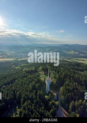 Vista aerea della cima della collina di Svatobor con una storica torre panoramica con una capanna turistica, una torre di telecomunicazioni e una torre di conversione TV Foto Stock