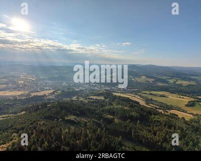 Vista aerea della cima della collina di Svatobor con una storica torre panoramica con una capanna turistica, una torre di telecomunicazioni e una torre di conversione TV Foto Stock