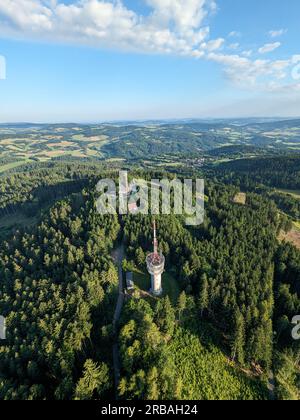 Vista aerea della cima della collina di Svatobor con una storica torre panoramica con una capanna turistica, una torre di telecomunicazioni e una torre di conversione TV Foto Stock