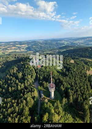 Vista aerea della cima della collina di Svatobor con una storica torre panoramica con una capanna turistica, una torre di telecomunicazioni e una torre di conversione TV Foto Stock