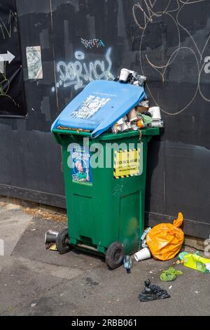 Bristol, Inghilterra - 16 giugno 2023: Il cestino è pieno di rifiuti in strada con l'adesivo Council aware Foto Stock